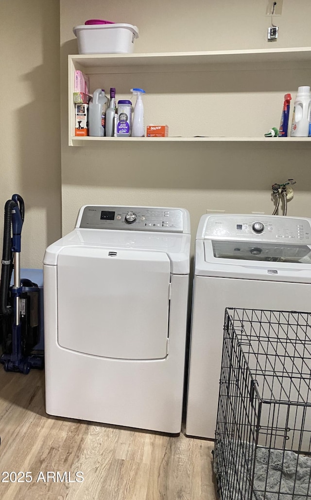 laundry room featuring laundry area, washer and clothes dryer, and light wood-type flooring