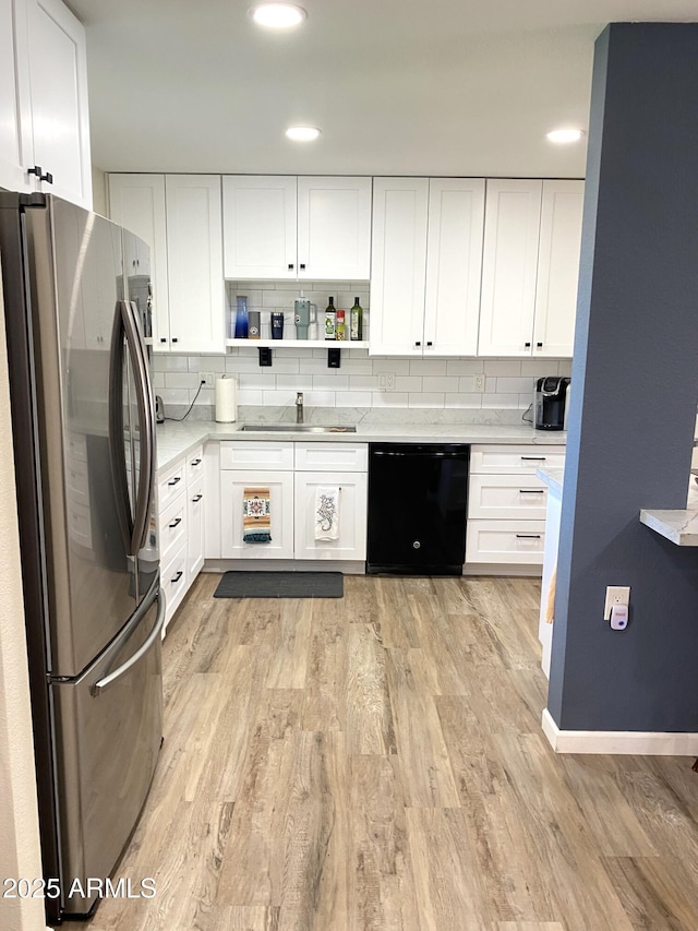 kitchen featuring light wood finished floors, open shelves, freestanding refrigerator, a sink, and dishwasher