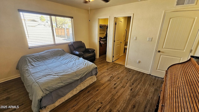 bedroom featuring dark hardwood / wood-style flooring, a walk in closet, ceiling fan, and a closet