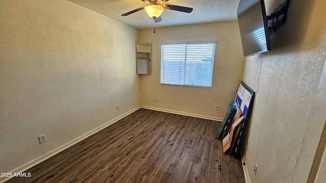 empty room with dark hardwood / wood-style floors and ceiling fan