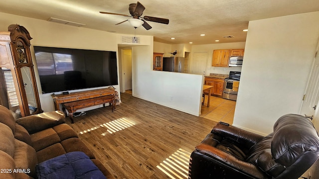 living room featuring ceiling fan and light wood-type flooring