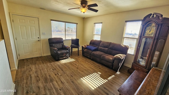 living room with ceiling fan and dark hardwood / wood-style flooring