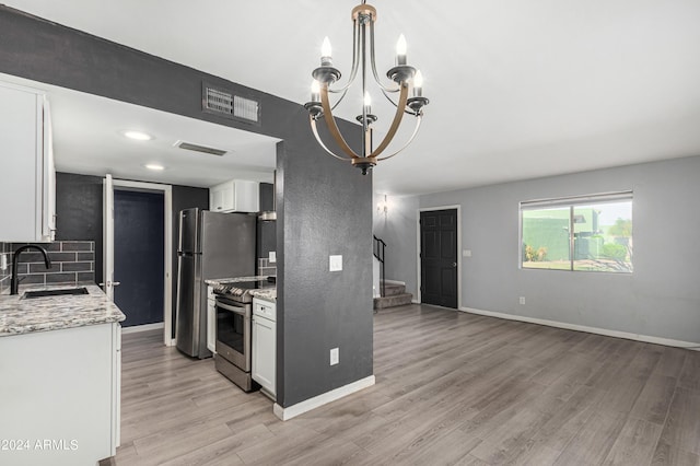 kitchen featuring light stone counters, sink, stainless steel appliances, and white cabinets