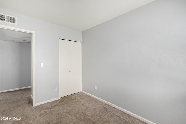 unfurnished bedroom with carpet and a closet