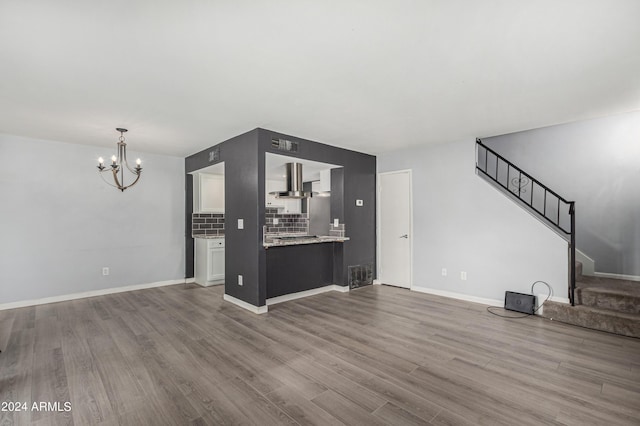 unfurnished living room featuring hardwood / wood-style floors and a notable chandelier