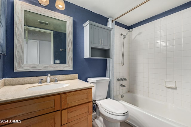 full bathroom featuring vanity, tiled shower / bath combo, and toilet