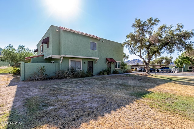 view of front of house with a mountain view and a front lawn