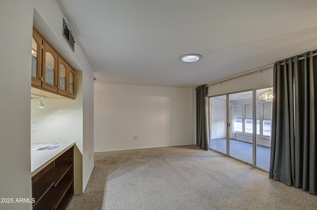 spare room featuring light carpet and visible vents