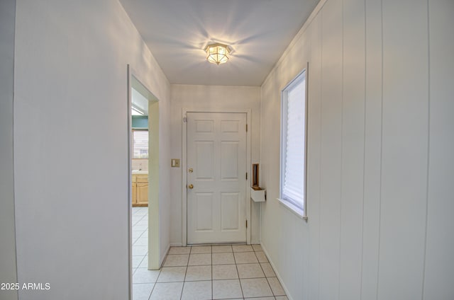 entryway featuring light tile patterned floors, baseboards, and a wealth of natural light