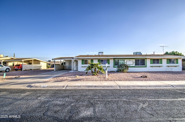 single story home featuring a carport and concrete driveway