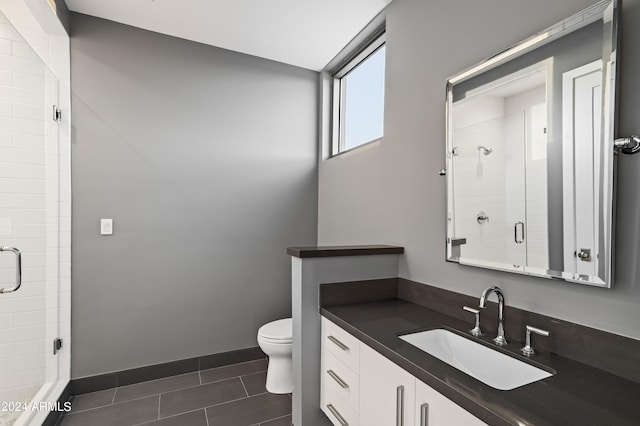 bathroom with tile patterned flooring, vanity, toilet, and an enclosed shower