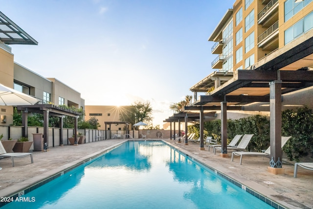 pool at dusk featuring a patio