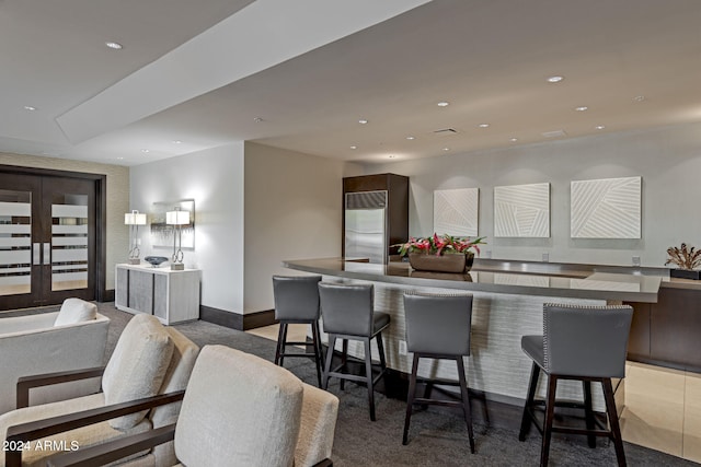 kitchen featuring stainless steel built in refrigerator, carpet flooring, and a large island