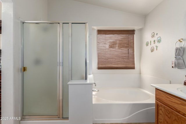 bathroom with a shower stall, vaulted ceiling, a bath, and vanity
