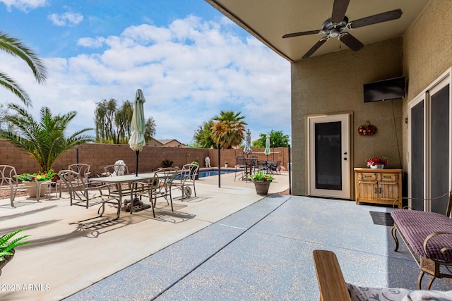 view of patio featuring a fenced backyard, a ceiling fan, outdoor dining area, and a fenced in pool