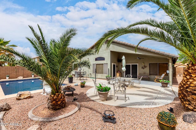 back of house featuring fence, stucco siding, ceiling fan, a patio, and a fire pit