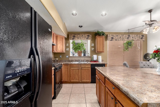 kitchen featuring brown cabinetry, black appliances, light tile patterned flooring, ceiling fan, and under cabinet range hood