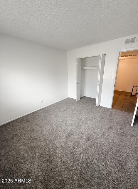 5975 N 48th Dr, Glendale, AZ 85301 - unfurnished bedroom with a textured ceiling, carpet, and a closet