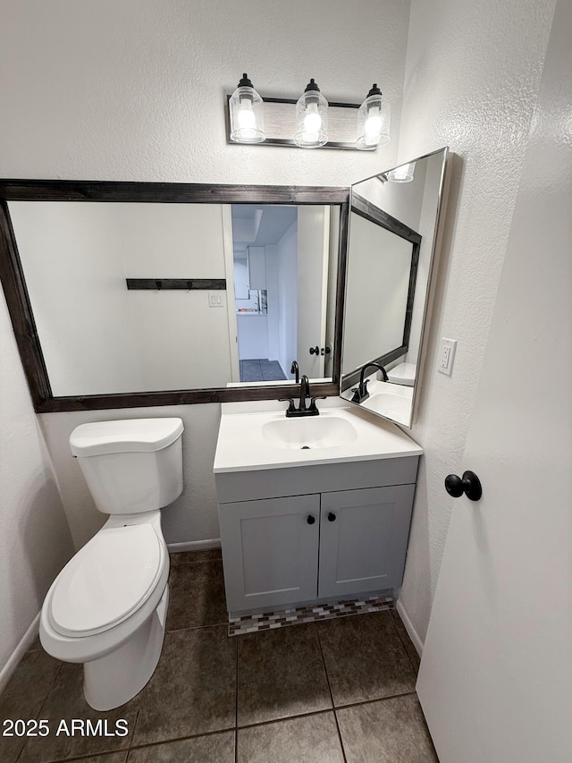 5975 N 48th Dr, Glendale, AZ 85301 - bathroom with toilet, vanity, tile patterned flooring, a textured wall, and baseboards