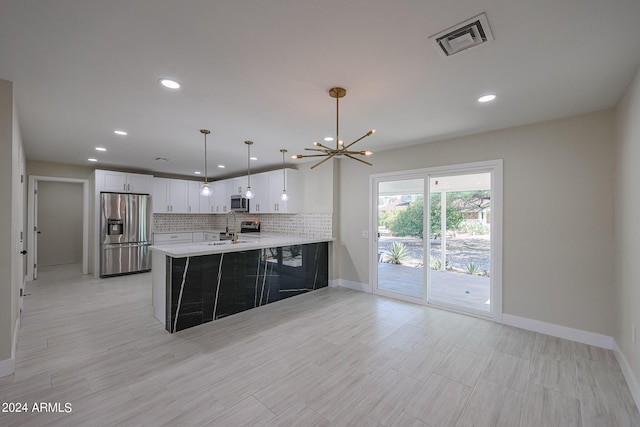 kitchen with white cabinets, hanging light fixtures, sink, kitchen peninsula, and appliances with stainless steel finishes