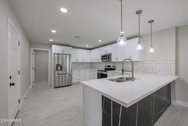 kitchen with stainless steel appliances, kitchen peninsula, white cabinets, and sink