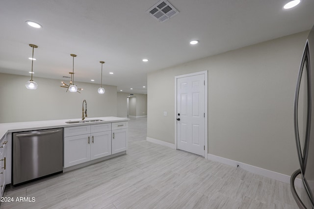 kitchen featuring refrigerator, sink, dishwasher, hanging light fixtures, and white cabinetry