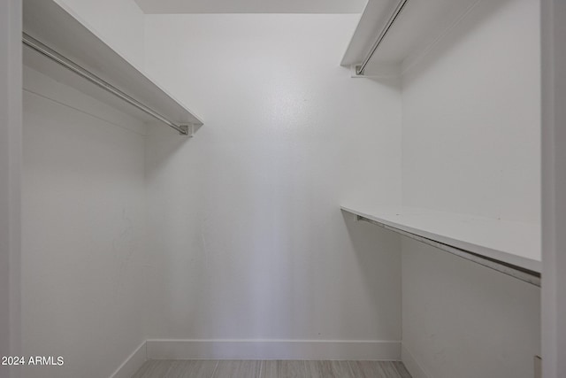 walk in closet with wood-type flooring