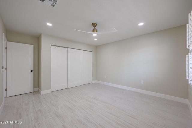 unfurnished bedroom with ceiling fan, a closet, and light wood-type flooring