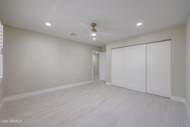 unfurnished bedroom featuring ceiling fan, a closet, and light hardwood / wood-style flooring