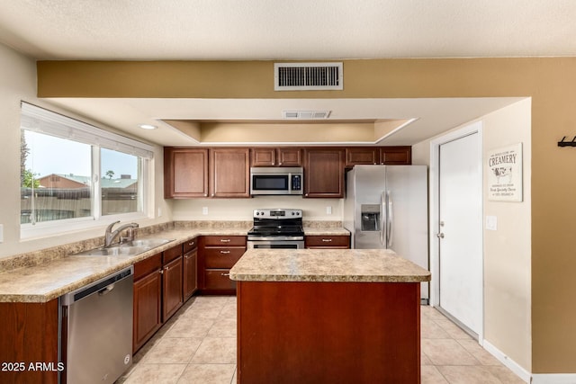 3415 E Anderson Dr, Phoenix, AZ 85032 - kitchen with appliances with stainless steel finishes, a sink, a center island, light tile patterned flooring, and light countertops