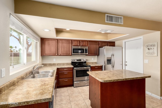 3415 E Anderson Dr, Phoenix, AZ 85032 - kitchen featuring appliances with stainless steel finishes, a sink, light tile patterned flooring, a tray ceiling, and a kitchen island