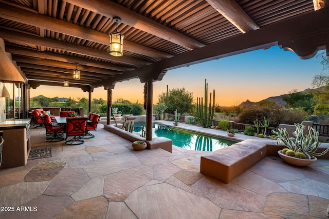 pool at dusk with a patio area