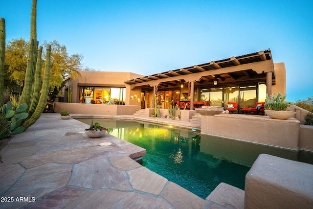 pool at dusk featuring a patio area