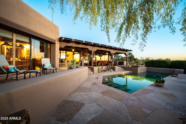 pool at dusk featuring a patio area