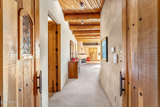 corridor featuring wood ceiling, light colored carpet, and beamed ceiling