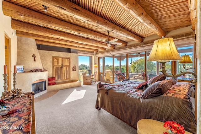 carpeted bedroom featuring rail lighting, beam ceiling, wood ceiling, access to outside, and a fireplace