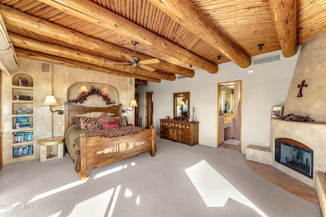 bedroom featuring beam ceiling, ensuite bathroom, and wood ceiling