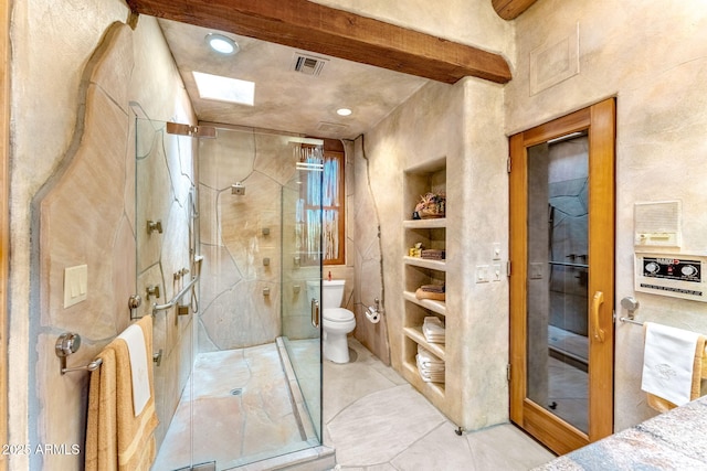 bathroom with tile patterned floors, built in features, toilet, and walk in shower