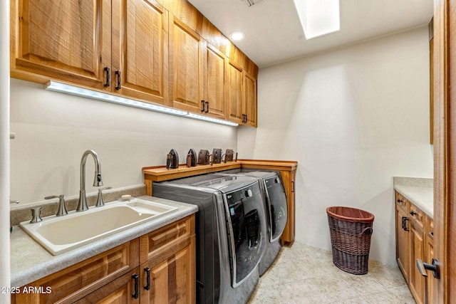 laundry room featuring light tile patterned flooring, cabinets, sink, and washer and dryer