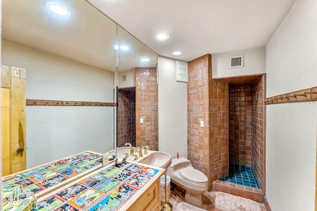 bathroom with toilet, sink, and a tile shower