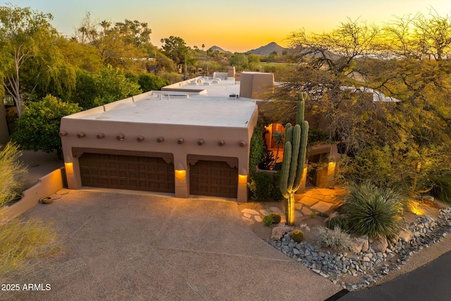 pueblo-style home with a mountain view and a garage