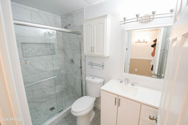 bathroom with an enclosed shower, vanity, and toilet