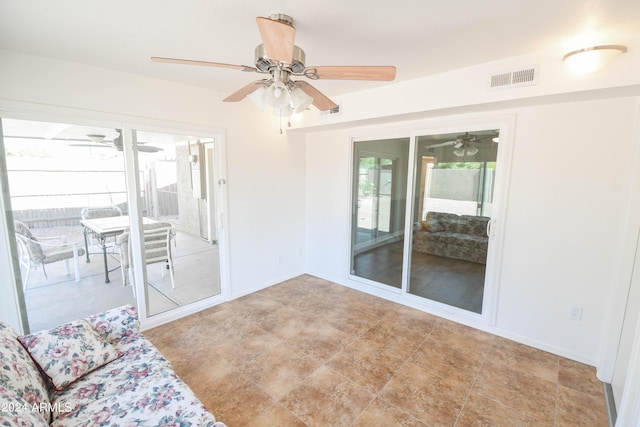 unfurnished sunroom featuring ceiling fan