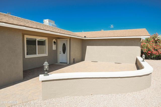 view of exterior entry featuring a patio area