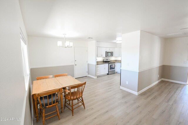 dining room with a notable chandelier and light hardwood / wood-style floors