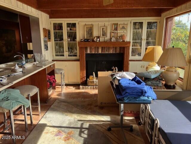 interior space with a brick fireplace, wood walls, and sink