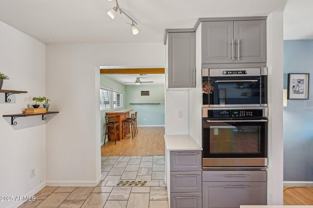 5133 E Keresan St, Phoenix, AZ 85044 - kitchen with gray cabinets, stainless steel double oven, track lighting, and baseboards