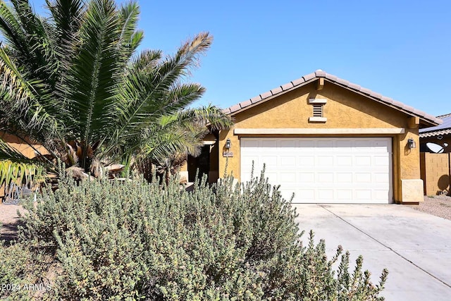 ranch-style home with a garage, concrete driveway, and stucco siding