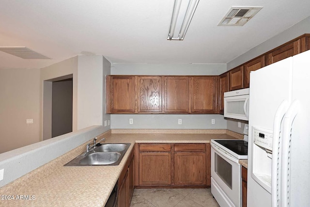 kitchen with light countertops, white appliances, a sink, and visible vents