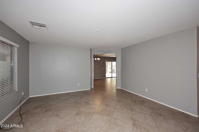 empty room featuring baseboards and visible vents